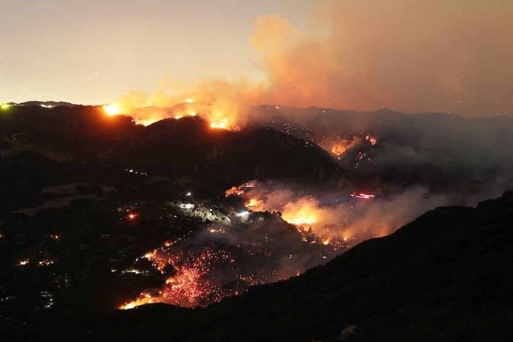 Las llamas y el humo del incendio de Palisades rodean una casa en la comunidad de Topanga, California, el 9 de enero de 2025. Los dos incendios más grandes que arden en Los Ángeles siguen cero por ciento contenidos el 9 de enero a pesar de las operaciones de extinción de incendios, dijeron las autoridades, que también prometieron abordar el saqueo de las casas evacuadas./AFP ,image_description: