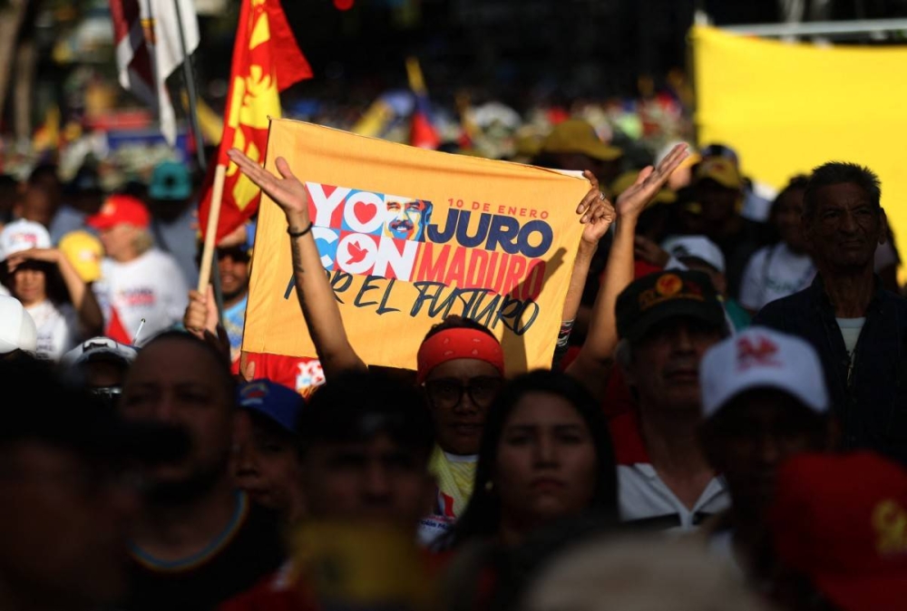 Partidarios del presidente de Venezuela, Nicolás Maduro, asisten a un mitin en vísperas de la toma de posesión presidencial en Caracas/ Foto Pedro Mattey AFP.,image_description: