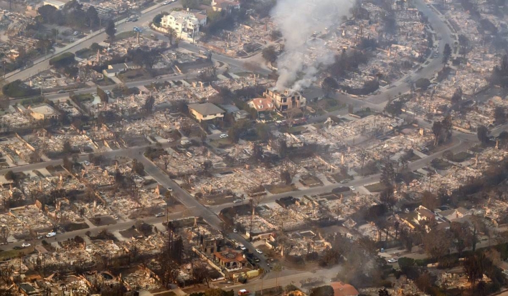 En esta vista aérea tomada desde un helicóptero, las casas quemadas por el incendio de Palisade arden sin llama cerca del vecindario Pacific Palisades de Los Ángeles, California, el 9 de enero de 2025. /JOSH EDELSON / AFP,image_description: