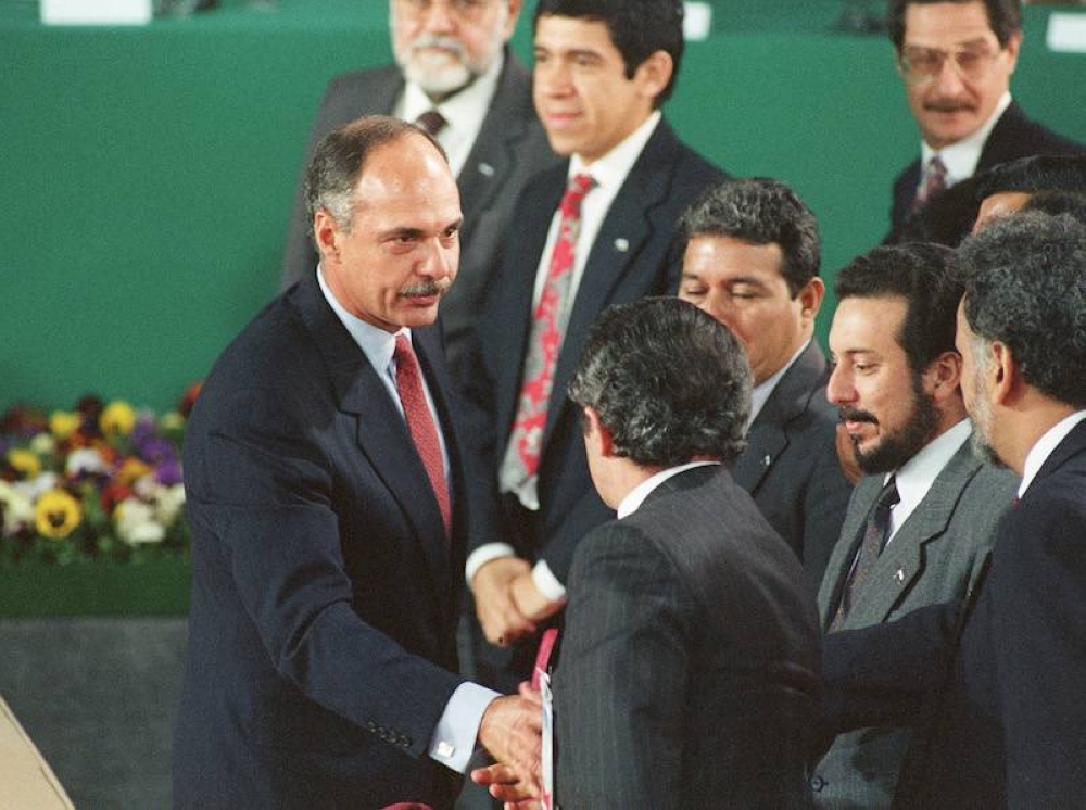 El entonces presidente salvadoreño Alfredo Cristiani (izq.) estrecha la mano de líderes guerrilleros Schafik Handal, Joaquín Villalobos, Salvador Sánchez y Francisco Jovel, tras la firma del acuerdo de paz en el Castillo de Chapultepec, México, el 16 de enero de 1992. / David Hernández-AFP.