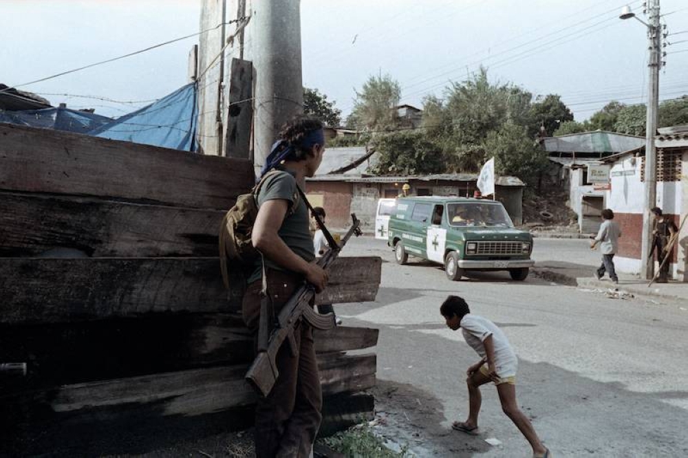 Una guerrilla salvadoreña (izq.) observa una ambulancia en Mejicanos, el 12 de noviembre de 1989. / Francisco Campos-AFP.