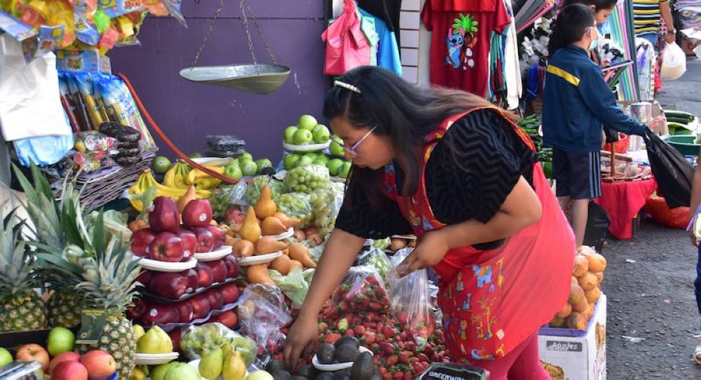 Una vendedora en el mercado central de San Salvador prepara bolsas con fresas para venderlas. / Juan Martínez.,image_description: