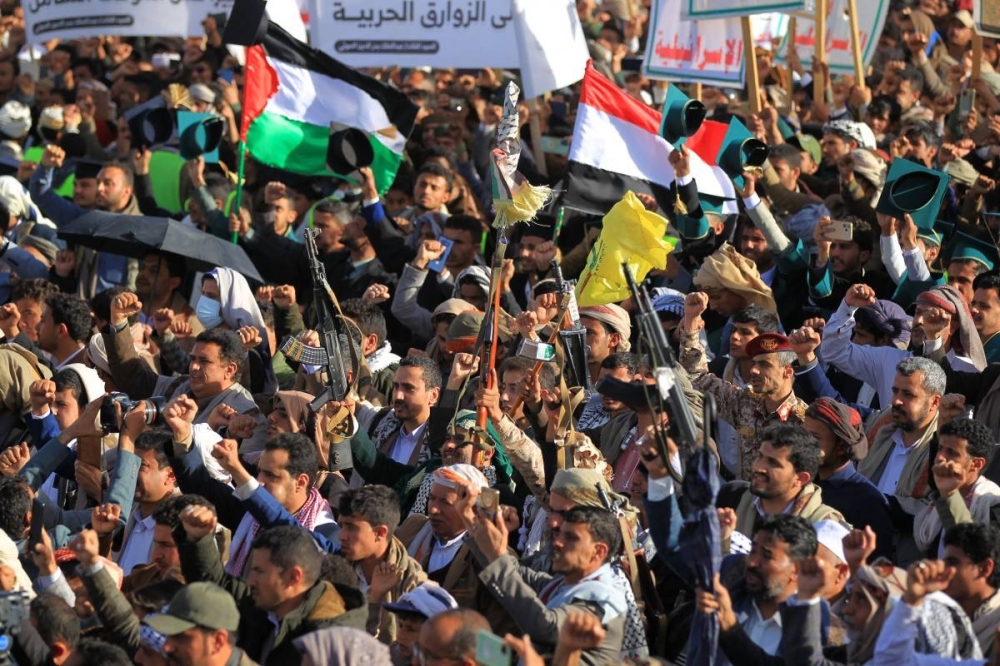 Yemeníes ondean banderas durante una manifestación para denunciar a Israel y en solidaridad con los palestinos en la capital, Saná, controlada por los hutíes, el 17 de enero de 2025. /AFP ,image_description: