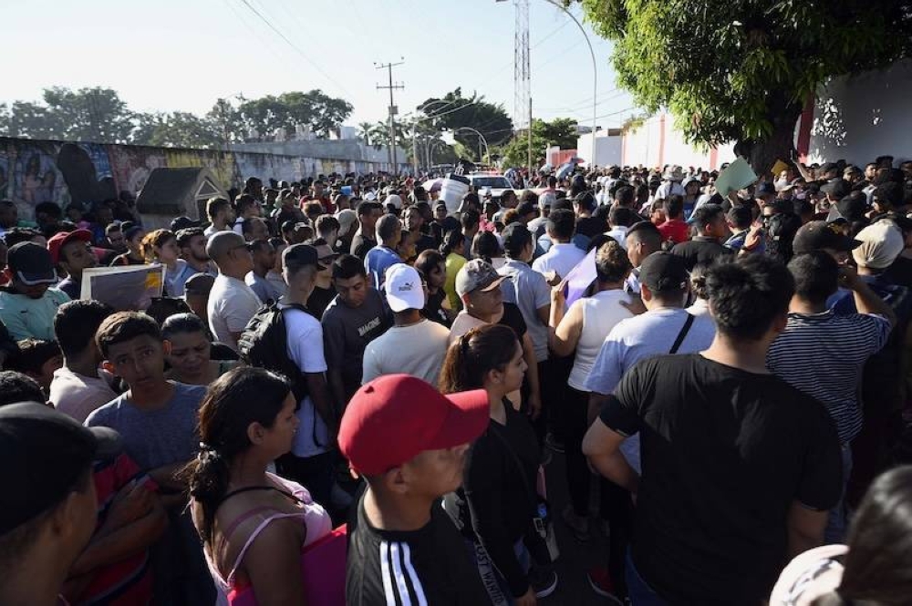 Los migrantes esperan afuera de la oficina regional del Instituto Nacional de Migración para esperar su salvoconducto para transitar por territorio mexicano en su camino a los Estados Unidos, en Tapachula, estado de Chiapas, México./ AFP