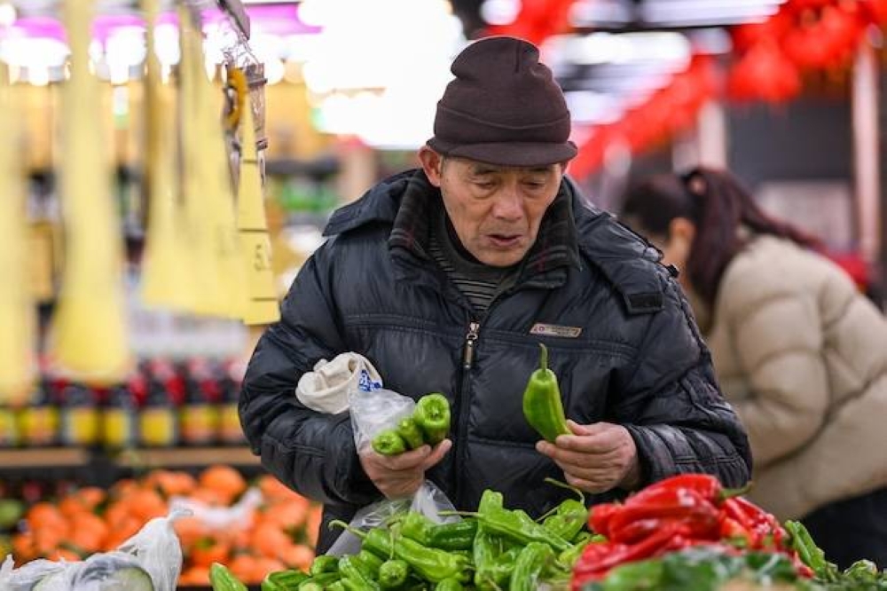 Un cliente escoge verduras en un supermercado en Nanjing, provincia oriental china de Jiangsu, el 17 de enero de 2025. China registró una de sus tasas de crecimiento económico más lentas en décadas el año pasado, según mostraron los datos el 17 de enero, mientras los líderes observan con nerviosismo un posible enfrentamiento comercial con el presidente entrante de Estados Unidos, Donald Trump./AFP