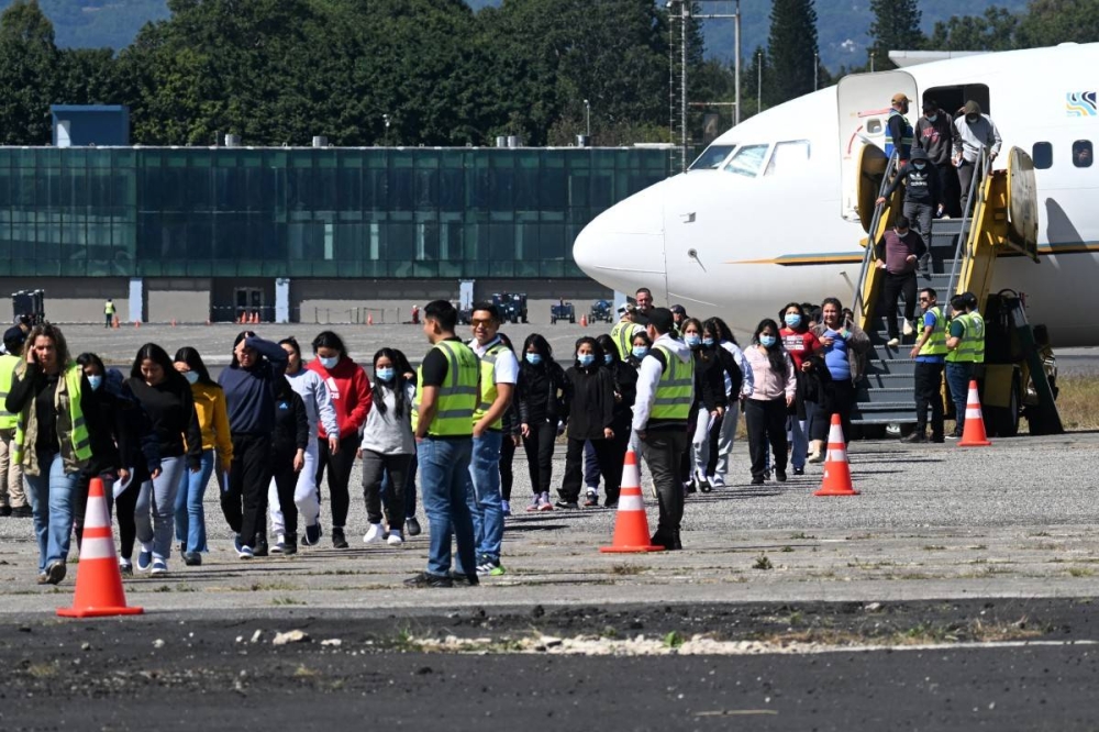 Los migrantes guatemaltecos deportados de Estados Unidos caminan por la pista tras llegar a la Base Aérea de Guatemala en la Ciudad de Guatemala el 10 de enero de 2025./AFP,image_description: