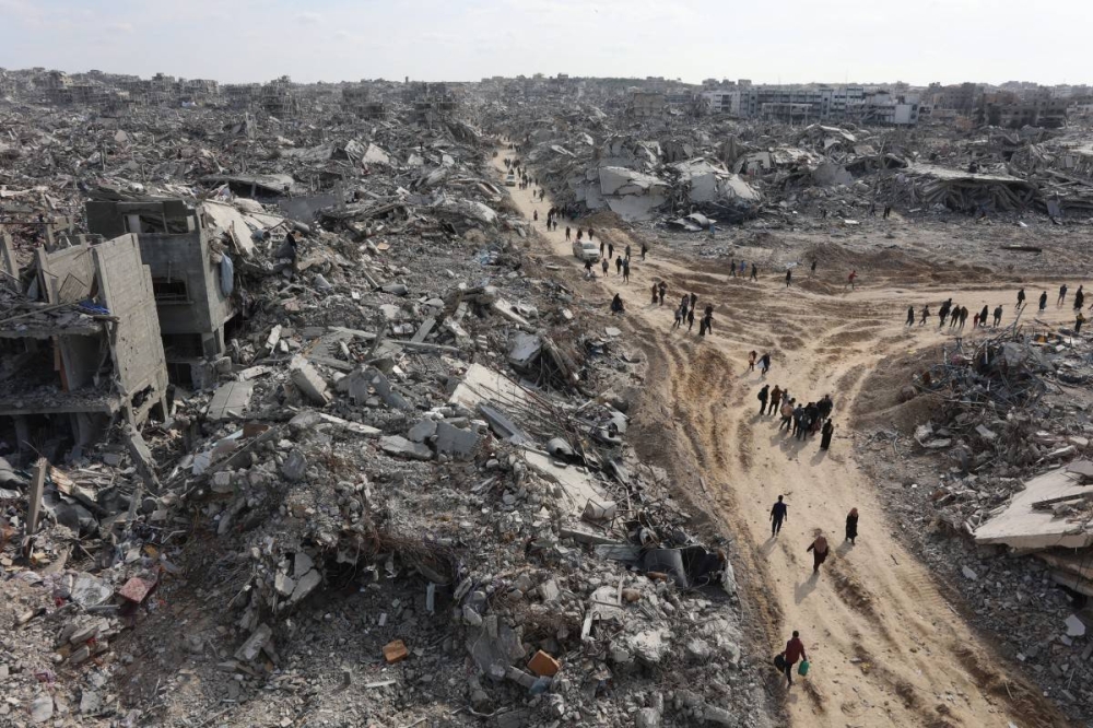 Esta vista aérea muestra a palestinos desplazados que regresan al campo de refugiados de Jabalia, devastado por la guerra, en el norte de la Franja de Gaza, el 19 de enero de 2025, poco antes de que se implementara un acuerdo de alto el fuego en la guerra entre Israel y el grupo militante palestino Hamás./ Foto de Omar AL-QATTAA / AFP