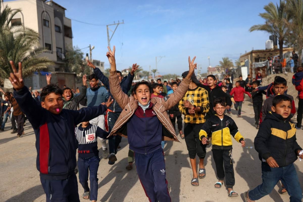 Los niños vitorean en Nuseirat, en el centro de la Franja de Gaza, el 19 de enero de 2025, poco antes de que se implementara un acuerdo de alto el fuego en la guerra entre Israel y el grupo militante palestino Hamás. (Foto de Bashar TALEB / AFP)