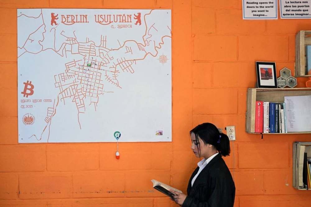 Un estudiante lee un libro en la sede del Centro Comunitario Bitcoin, un espacio creado para salvadoreños y extranjeros interesados ​​en las criptomonedas en Berlín, El Salvador, el 20 de enero de 2025. / Marvin Recinos/AFP