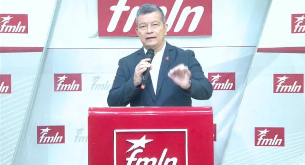 Manuel El Chino Flores, secretario general del FMLN en la conferencia semanal del partido. / Imagen de video FMLN.,image_description: